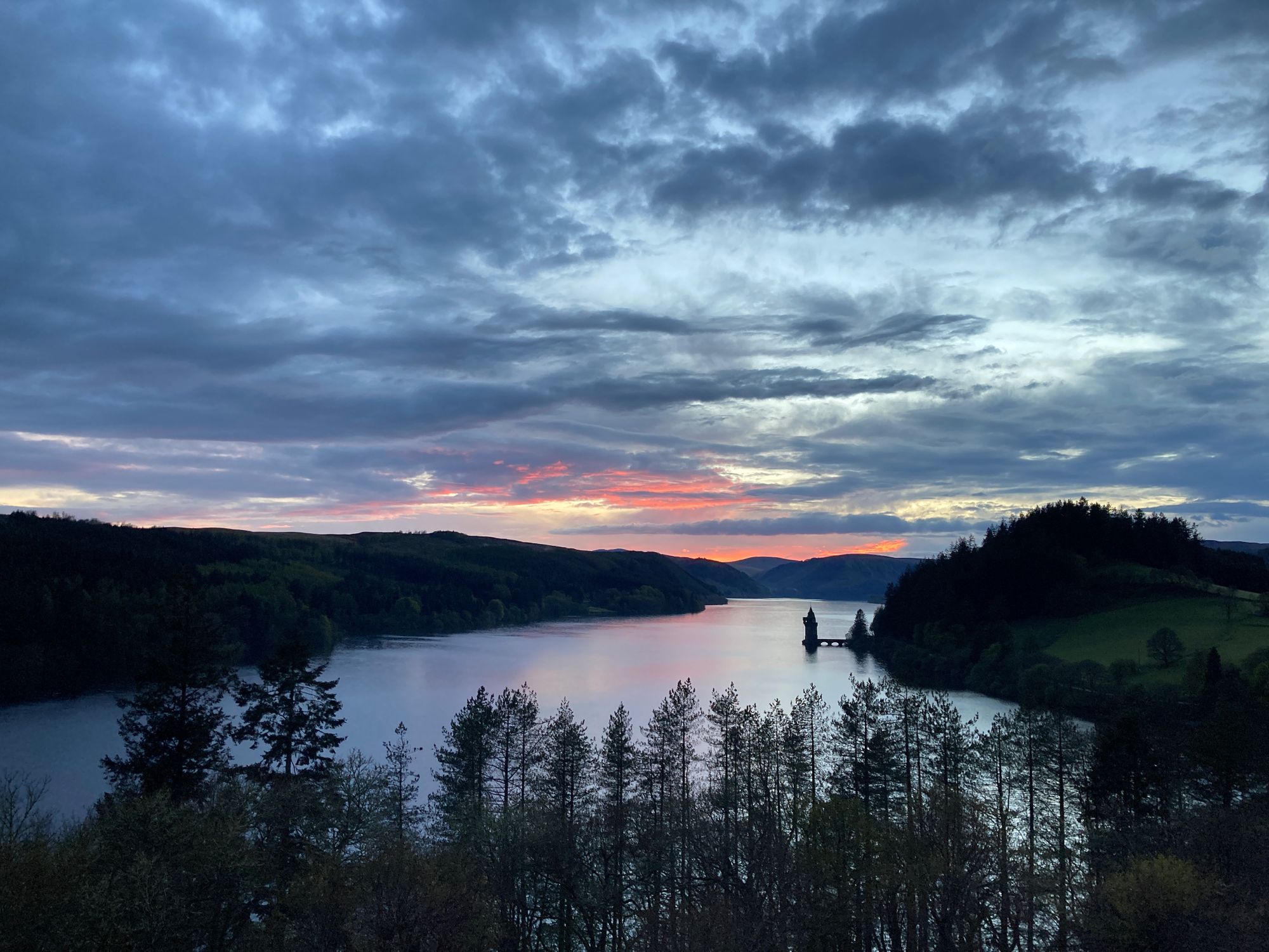 lake at sunset with trees in foreground lake at sunset with trees in foreground
