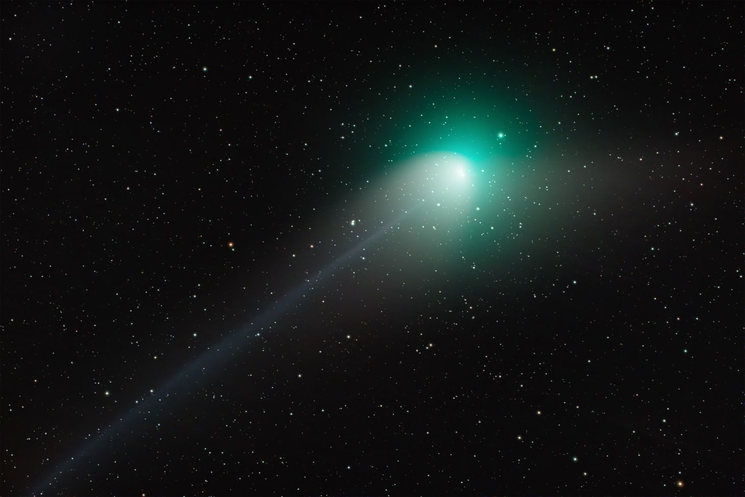 A comet with a greenish shade against a starry night sky