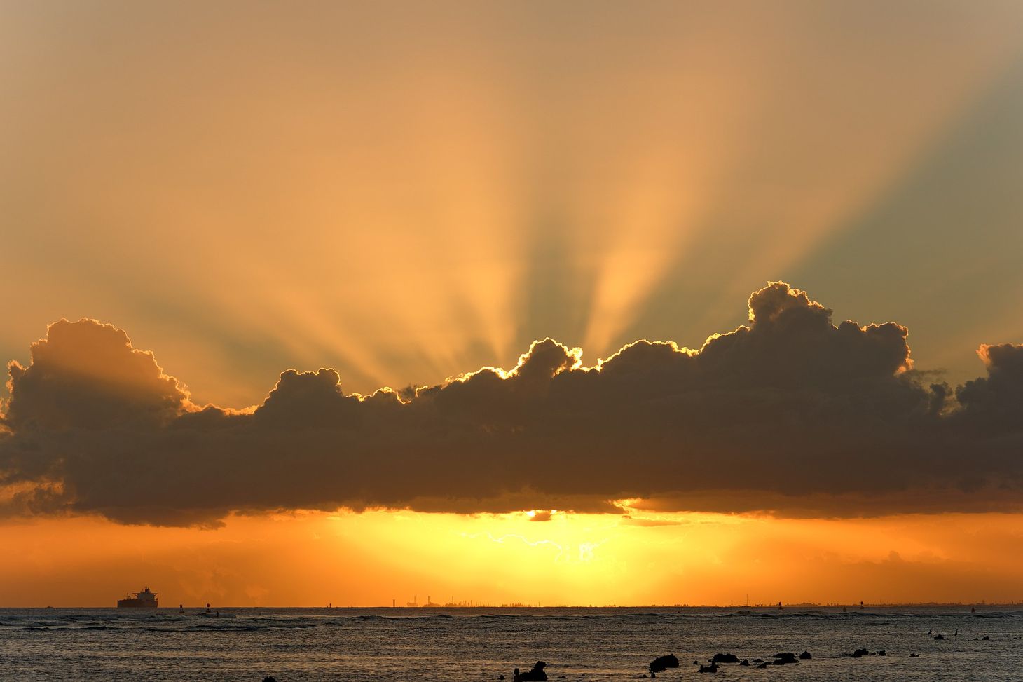 sun behind clouds with rays emerging